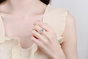 Close-up of 1 carat moissanite ring with pavé diamond setting on a silver band