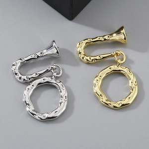 Detailed view of irregular trumpet earrings in gold and silver with metallic texture