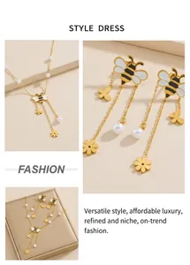 Detail of gold bee and flower jewelry set featuring pearls and enamel tassel chain