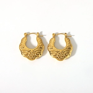 Détails macro de créoles vintage plaquées or 18 carats avec gaufrage floral ciselé