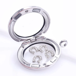 Open silver glass locket with four horseshoe charms featuring sparkling rhinestones