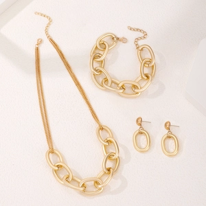 Detail of chunky gold chain jewelry set including necklace, bracelet and earrings