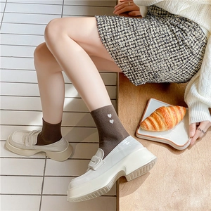 Women's crew socks in dark brown with heart embroidery paired with beige loafers