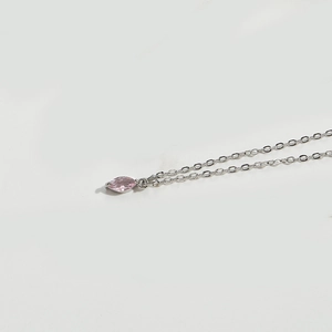 Detail view of a pink marquise-cut gemstone pendant on a fine silver-toned chain