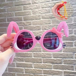 Detailed view of pink rabbit-shaped kids sunglasses with cute bow and ear frames
