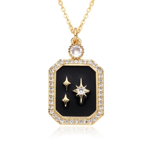 Detailed macro view of a rectangular gold pendant with black inlay and sparkling stars