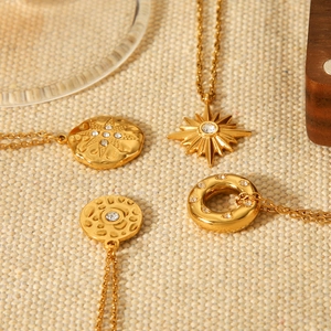Detailed view of 18K gold plated celestial pendants with starburst and moon textures
