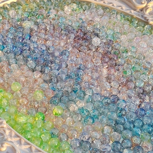 Mix of 8mm-10mm colorful cracked glass beads for DIY jewelry making in a white tray