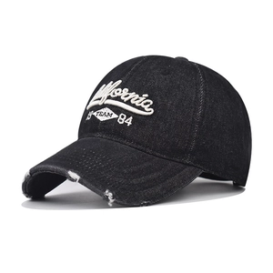 Detailed view of California 1984 embroidery and distressed edges on washed black denim cap