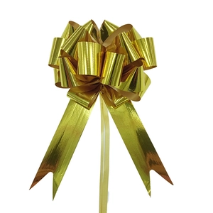 Detail of 3D metallic golden gift pull bow showing shiny finish and V-shaped ribbon tails