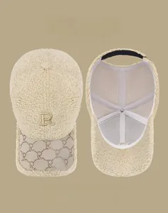 Détail d'une casquette en polaire beige avec broderie lettre R et visière texturée
