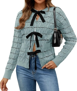 Detail of light blue cable knit cardigan with black bow tie fasteners and striped texture