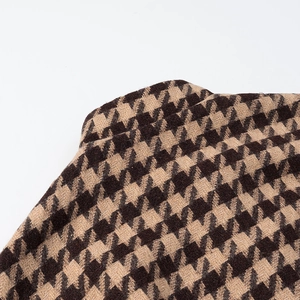 Close-up of the coffee black houndstooth pattern and tweed fabric texture on the collar