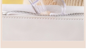 Detailed close-up of white lychee texture leather medicine pouch with silver metal zipper