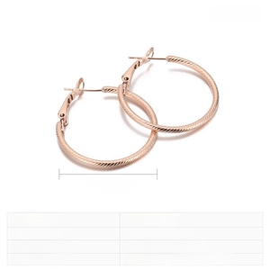 Detail of rose gold stainless steel hoop earrings with spiral texture and 30mm size specs