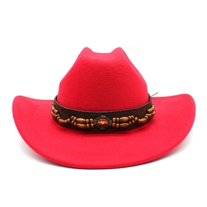 Détail du chapeau de cowboy en feutre rouge avec bande en cuir, perles et pierre centrale