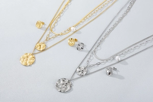 Detailed set of gold and silver layered necklaces with hammered circular pendants and pearls