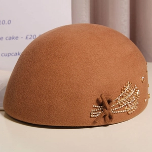 Detail of wool cloche hat with crystal wheat ear cluster and felt bow decoration