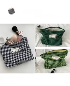 Detail of Houndstooth makeup bags in various colors with metallic zippers and fabric labels