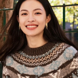 Maillard style resin tassel earrings and brown knit sweater on a female model
