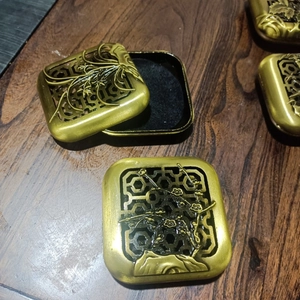 Detailed close-up of antique gold alloy incense box with traditional bamboo cutout lid