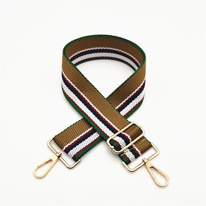 Close-up of vintage multi-color striped canvas bag strap with golden metal lobster clasps