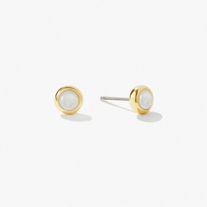 Close-up of round gold stud earrings with elegant white mother of pearl inlay