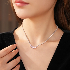 Detailed close-up of a zircon pendant necklace with pink stones on a fashion model neck