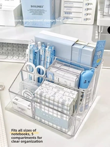 Close-up of a 5-compartment clear acrylic desk organizer with stationery items