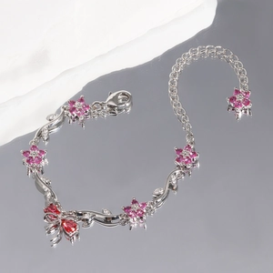Details eines luxuriösen Silberarmbands mit pinken Blumensteinen und Karabinerverschluss