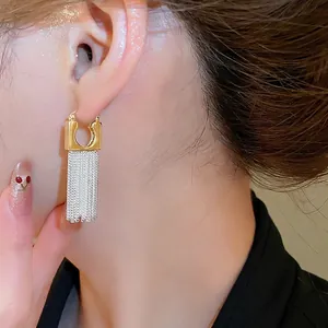 14k gold plated U-shape earrings with long silver tassel chains on female model