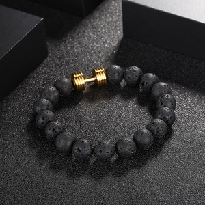 Bracelet en pierre de lave noire avec breloque haltère dorée pour un style fitness chic