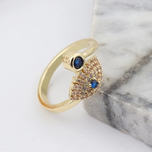 Detailed view of adjustable gold snake ring with evil eye blue and champagne crystals