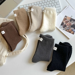Close-up of thick winter wool socks in solid colors with minimalist fabric labels