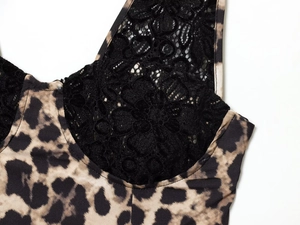 Detailed close-up of leopard print fabric and intricate black lace stitching on dress