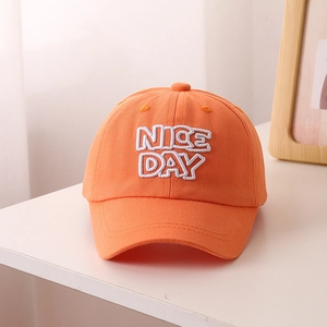 Détail de la broderie 3D Nice Day blanche sur une casquette de baseball orange pour enfants