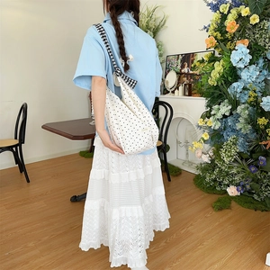 Detailed shot of white polka dot canvas bag with stylish black and white checkered strap