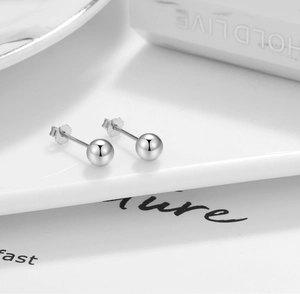 Macro shot of S925 sterling silver ball studs showing polished finish and S925 engraving
