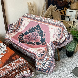 Close-up of pink and blue bohemian woven blanket with geometric patterns and tassels