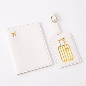 Close-up of white PU leather passport holder and luggage tag set with gold foil design