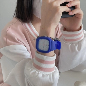 Detail of blue silicone square watch with metal chain strap worn by a student