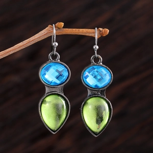 Gros plan de boucles d'oreilles vintage en argent avec pierres bleues et vertes