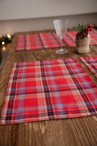 Close-up of red tartan placemat texture with neat stitching on wooden table