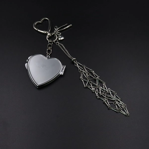 Detailed view of silver heart pendant with chain and geometric metal mesh tassel details