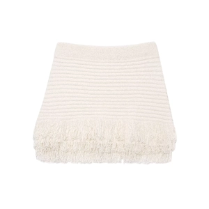Detailed view of white knit mini skirt featuring horizontal texture and fringe trim