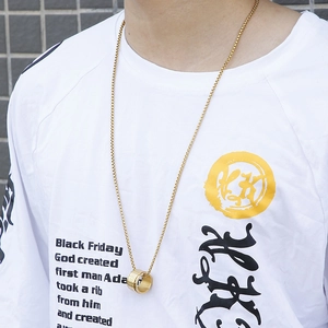 Close-up of a gold stainless steel spinner ring pendant on a long chain worn by a male model