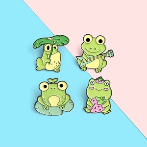 Set of four cartoon frog enamel pins featuring guitar, strawberry, and lily pad designs
