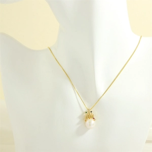 Close-up of crown pendant with colorful gemstones and white pearl on a gold chain