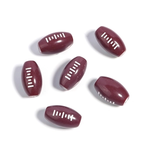 Macro detail of brown acrylic rugby beads with white stitching for DIY jewelry making