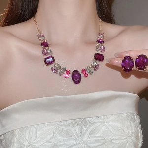 Macro detail of royal vintage necklace and earrings set with purple oval gemstones